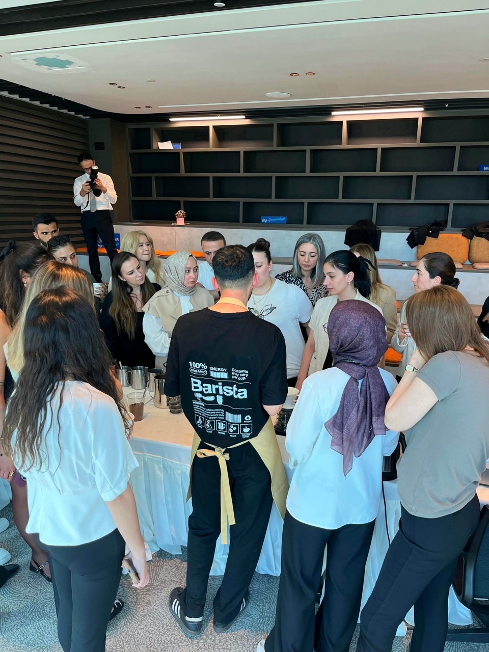 A group gathered around a table with coffee equipment