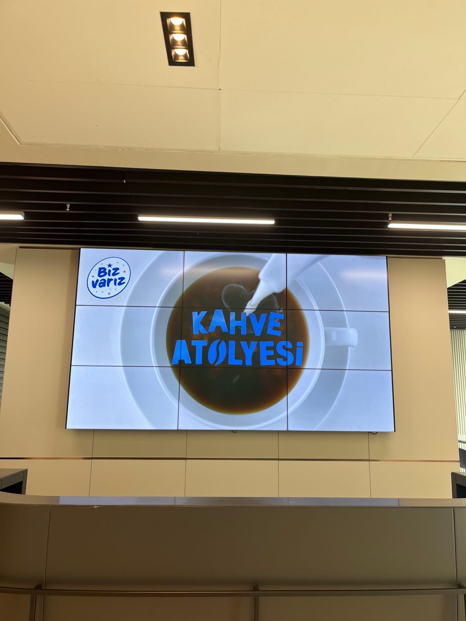 A large screen displaying Coffee Workshop at an event space